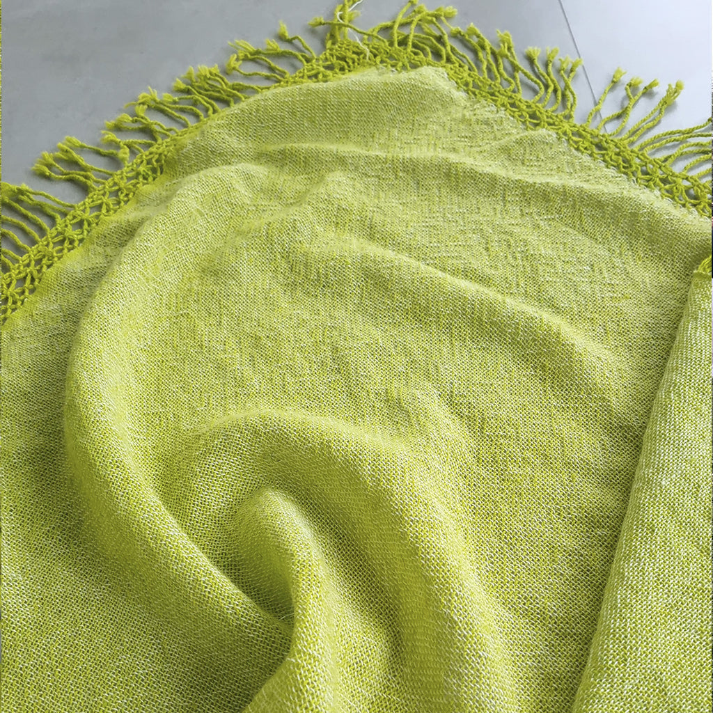 Bright green wool ruana wrap worn outdoors over the shoulders